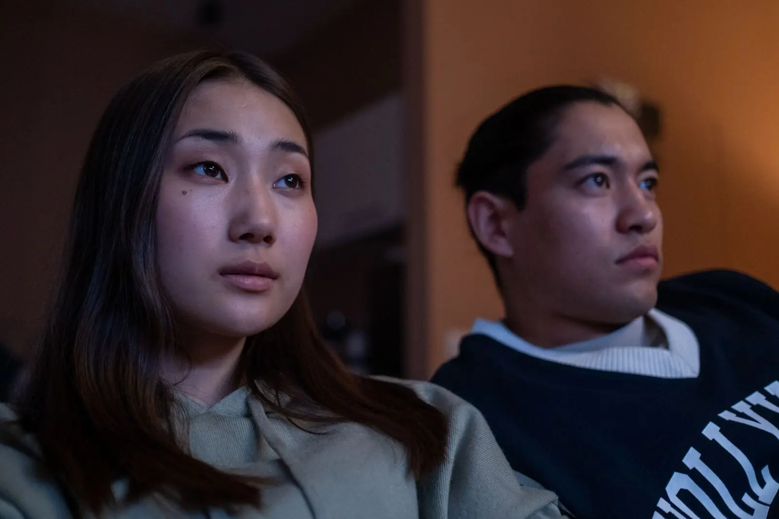 Someone watching their film in a dark room, lit by the screen